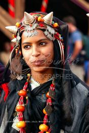 Image du Maroc Professionnelle de  Une jeune fille du désert pose en tenue traditionnelle durant le grand Moussem de Tan Tan. Ce grand rassemblement est organisé dans un site désertique sur lequel la ville de Tan Tan a toujours accueilli la majorité des tribus et des grandes familles nomades du désert lors d'un grand moussem, Samedi 18 septembre 2004. (Photo / Abdeljalil Bounhar)




